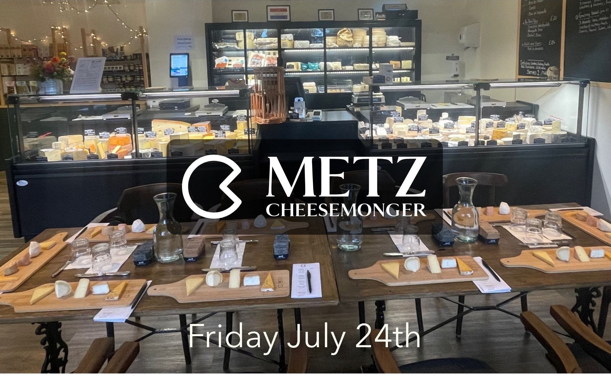 Cheese display case with Metz Cheese Monger branding in a cheese shop.